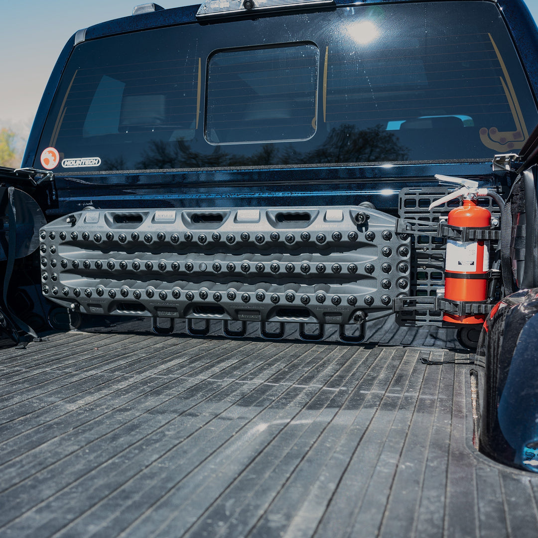 Recovery boards mounted to a bulkhead rail in a Ford Raptor truck bed